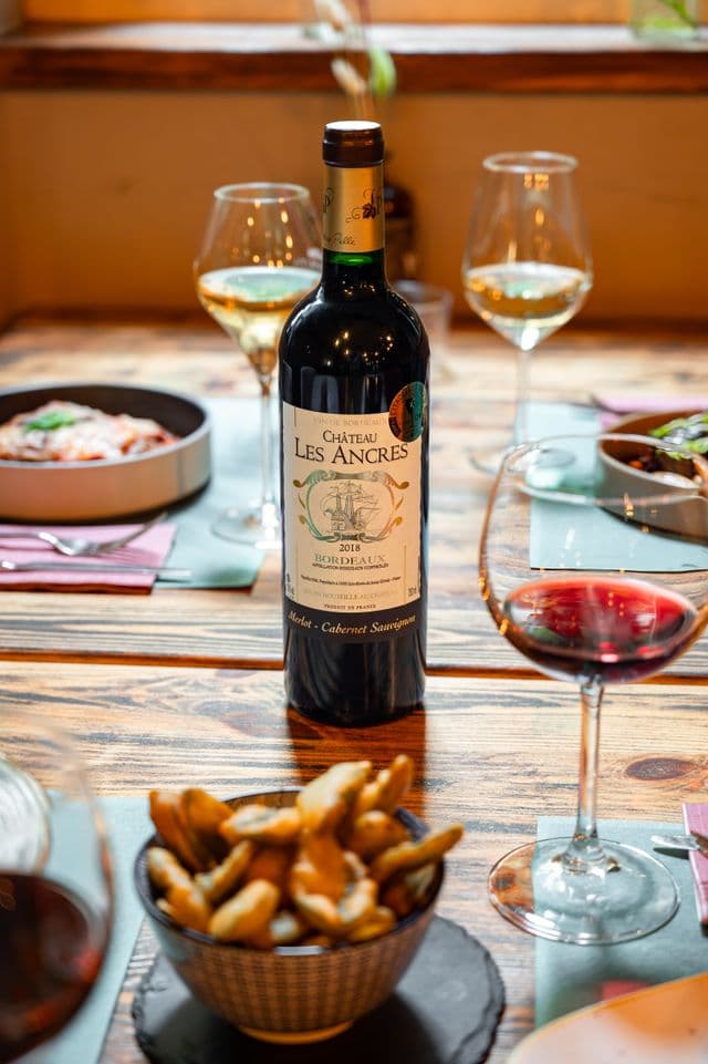 Bouteille de vin et amuse-bouches sur une table en bois